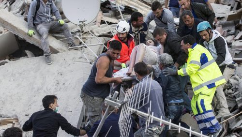 epa05508233 An injured woman (C) is carried by rescuers amid the rubble of collapsed buildings in Amatrice, central Italy, 24 August 2016, following a 6.2 magnitude earthquake, according to the United States Geological Survey (USGS), that struck at around 3:30 am local time (1:30 am GMT). The quake was felt across a broad section of central Italy, including the capital Rome where people in homes in the historic center felt a long swaying followed by aftershocks. According to reports at least 21 people died in the quake, 11 in Lazio and 10 in Marche regions. EPA/MASSIMO PERCOSSI